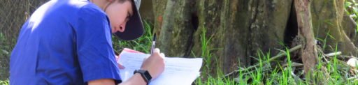 Young woman in blue shirt writing on paper