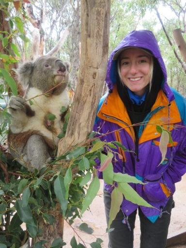 Student posing with a baby animal