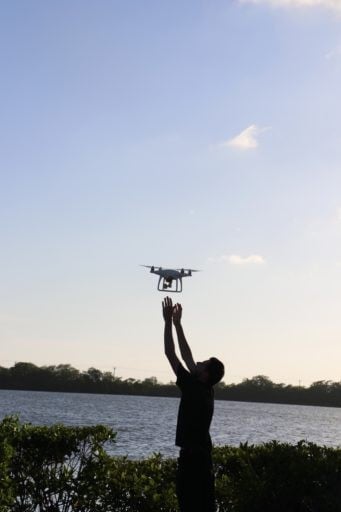 Man launching a drone to fly up